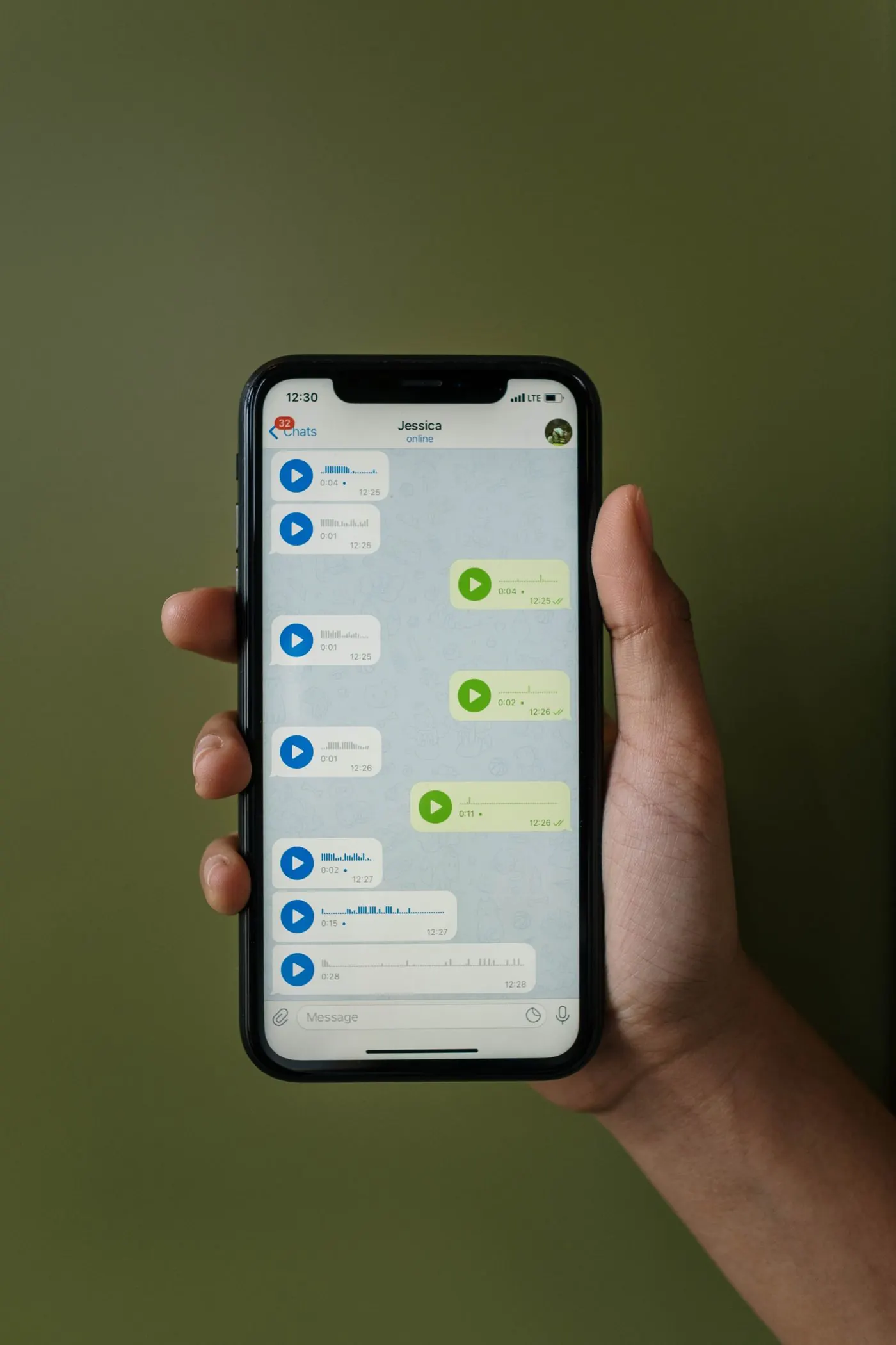 Mão segurando um celular com conversa aberta